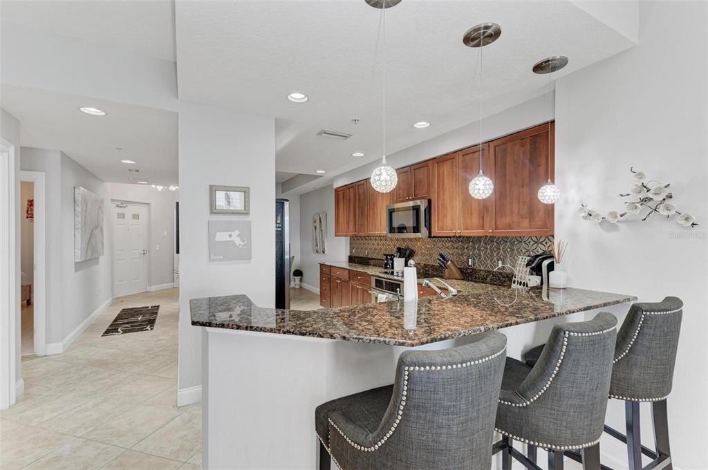 611 Riviera Dunes Way, Unit 304 Palmetto, FL 34221 - Photo 7 of 30 a kitchen with granite countertop kitchen island stainless steel appliances a sink and a counter top space