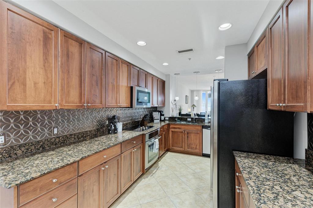 611 Riviera Dunes Way, Unit 304 Palmetto, FL 34221 - Photo 10 of 30 a kitchen with stainless steel appliances granite countertop a refrigerator sink and stove