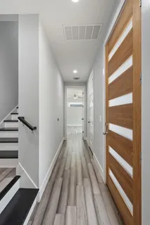 a view of a hallway with wooden floor and closet