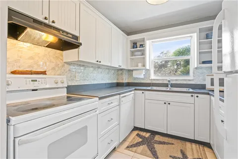 a kitchen with white cabinets and white appliances