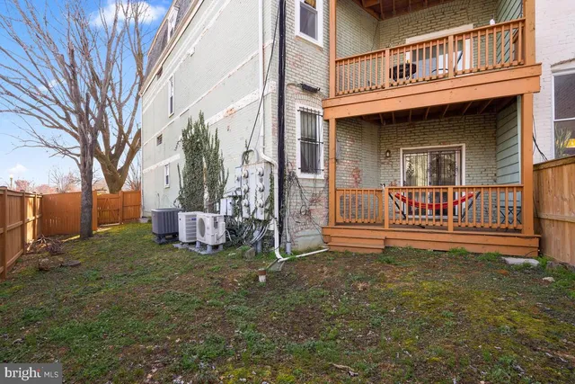 a view of a house with a yard and wooden fence