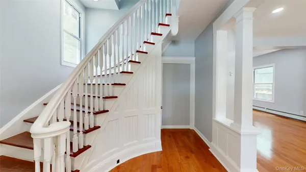 a view of staircase with wooden floor and white walls