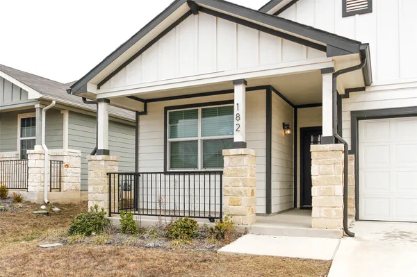 a kitchen with stainless steel appliances granite countertop a refrigerator a stove a sink a microwave and white cabinets with wooden floor