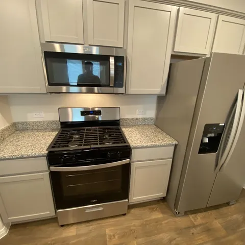 a stove top oven sitting inside of a kitchen