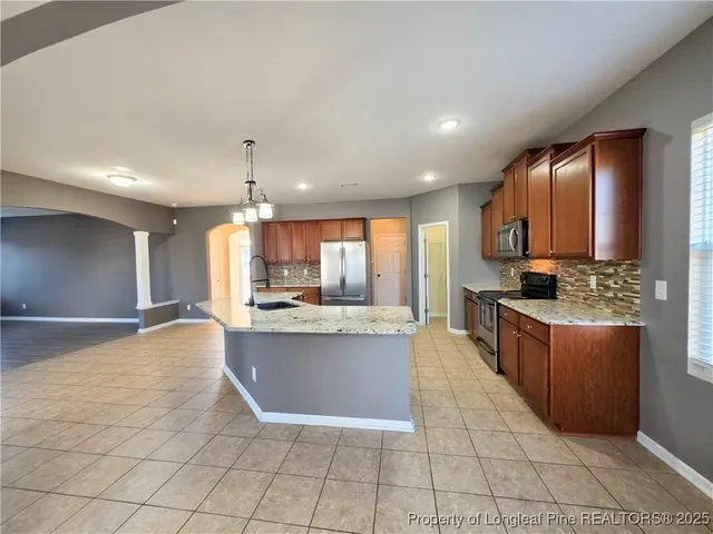 a large kitchen with a large counter top and stainless steel appliances