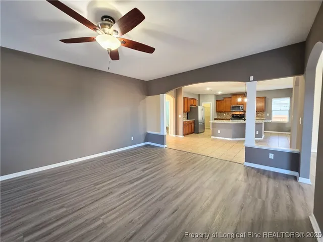 an empty room with wooden floor and chandelier