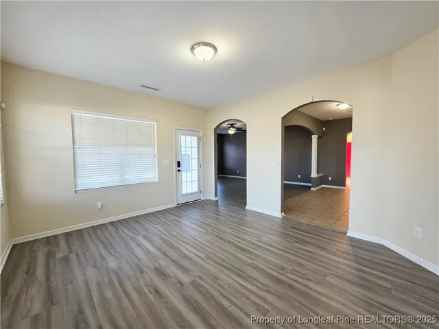 a view of empty room with wooden floor