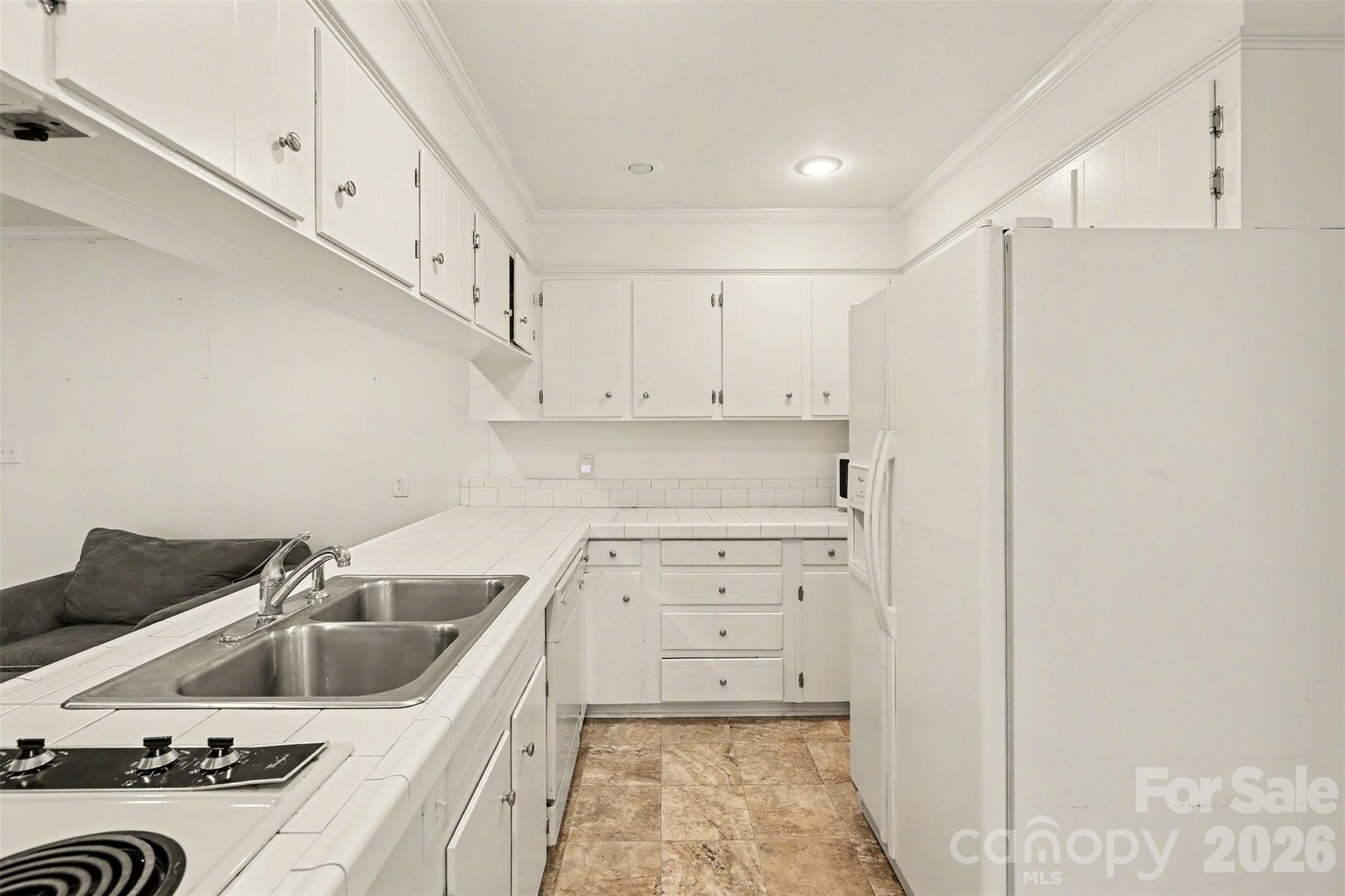 3101 Eastburn Road Charlotte, NC 28210 - Photo 12 of 31 a kitchen with white cabinets a sink a stove and a refrigerator with cabinets
