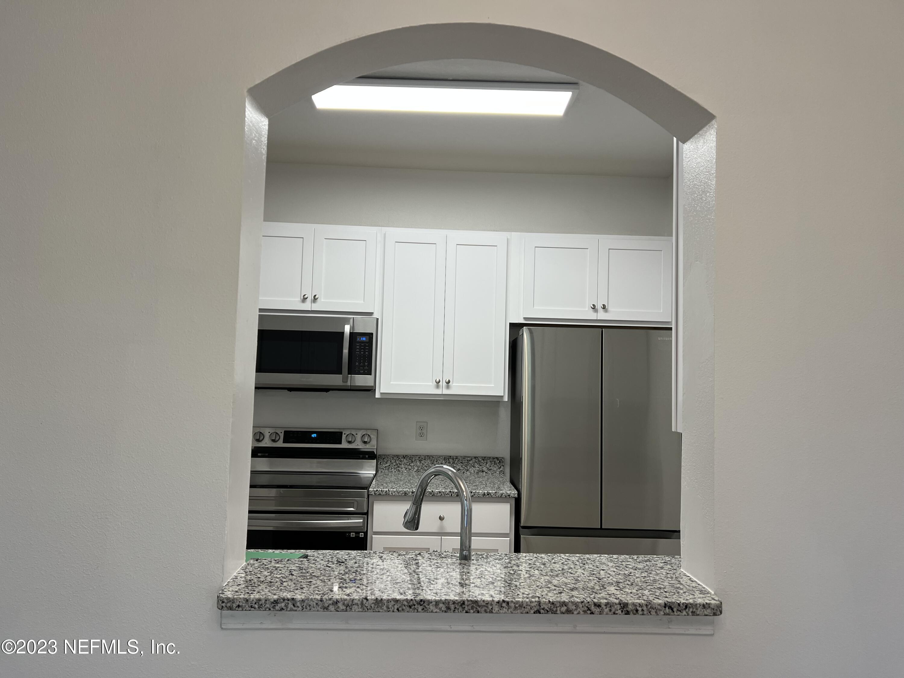 7990 Baymeadows Road East, Unit 418 Jacksonville, FL 32256 - Photo 12 of 25 a kitchen with a refrigerator and a sink