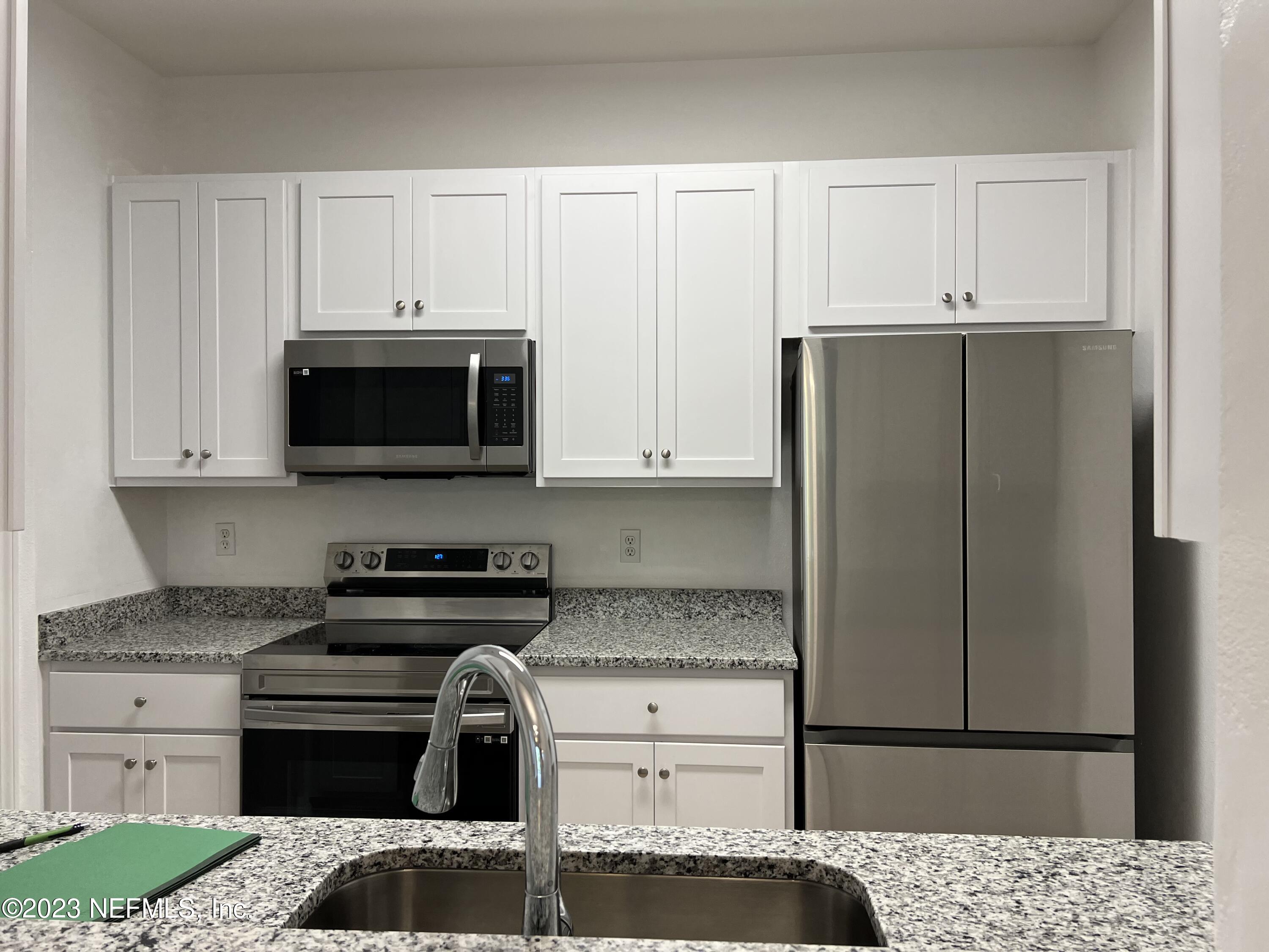 7990 Baymeadows Road East, Unit 418 Jacksonville, FL 32256 - Photo 13 of 25 a kitchen with a stove and a refrigerator