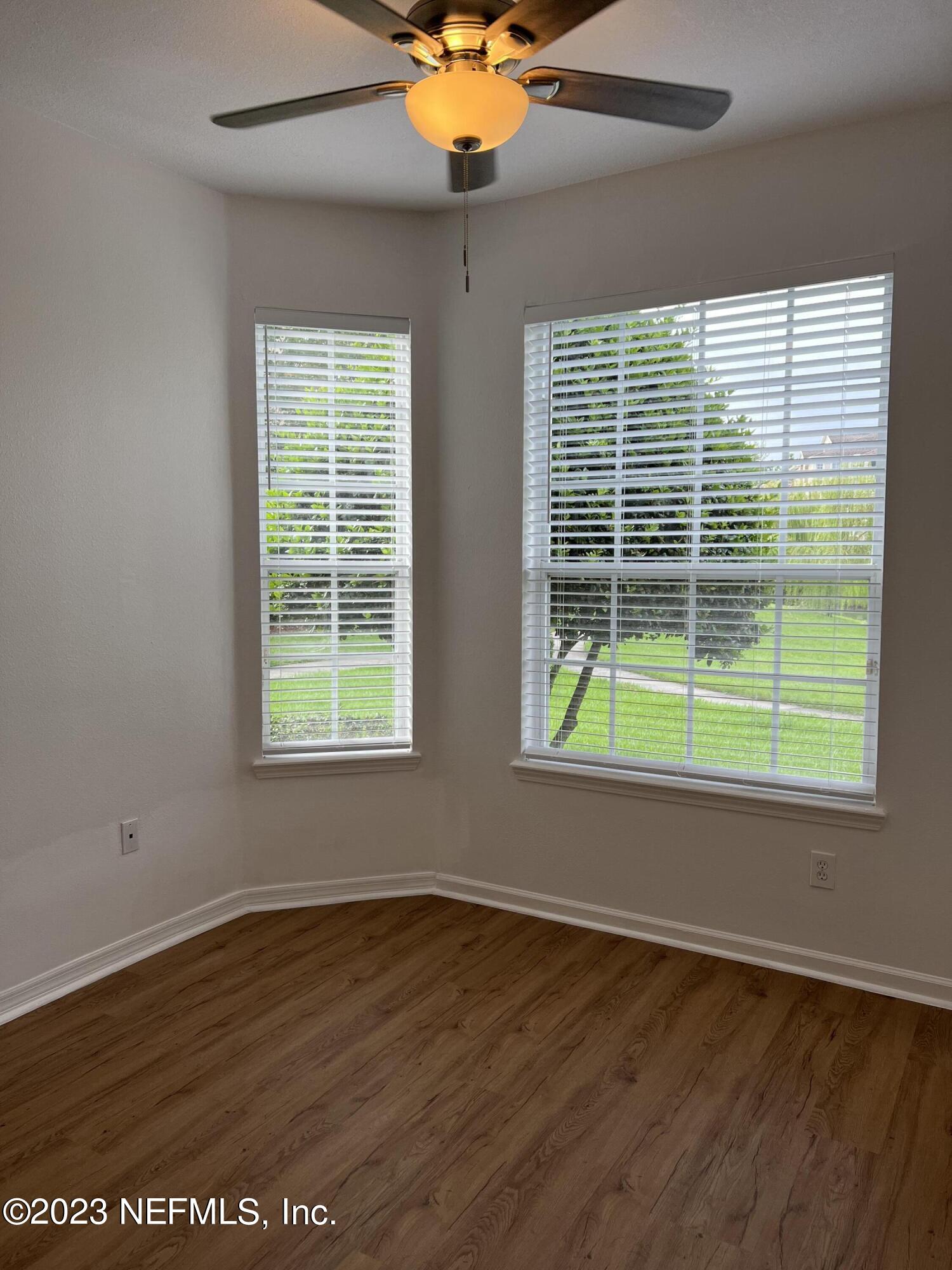 7990 Baymeadows Road East, Unit 418 Jacksonville, FL 32256 - Photo 15 of 25 an empty room with wooden floor fan and windows