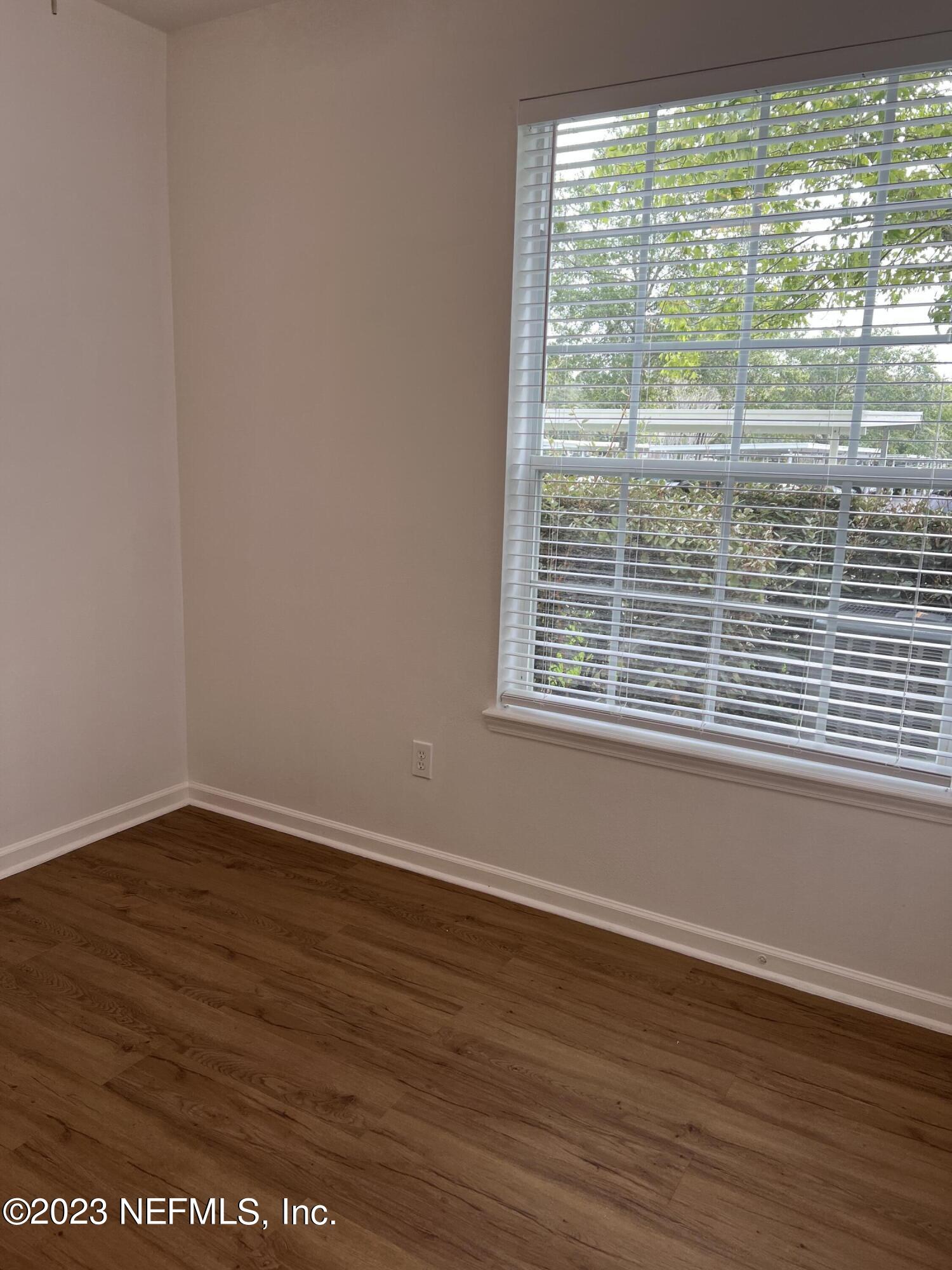 7990 Baymeadows Road East, Unit 418 Jacksonville, FL 32256 - Photo 17 of 25 a view of an empty room with wooden floor and a window