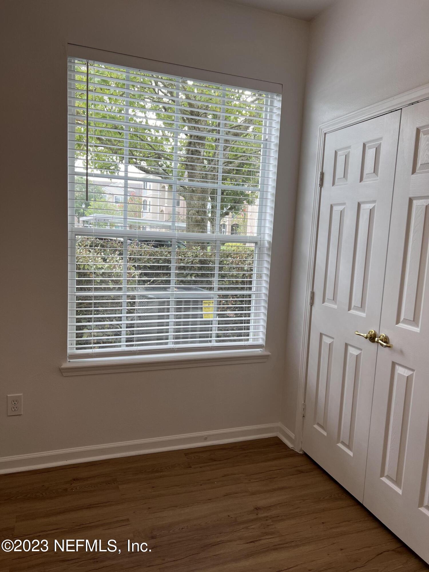 7990 Baymeadows Road East, Unit 418 Jacksonville, FL 32256 - Photo 20 of 25 a view of an empty room with wooden floor and a window