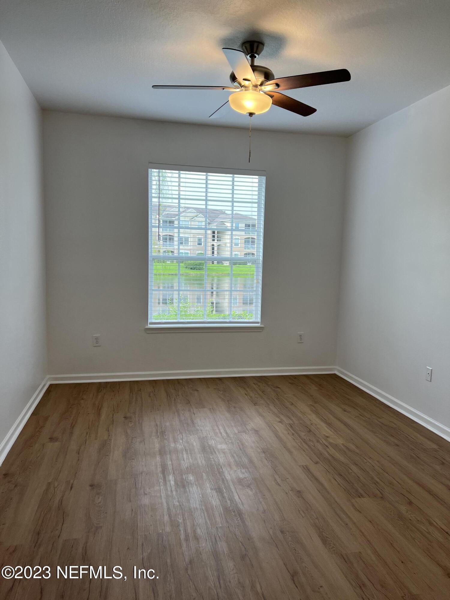 7990 Baymeadows Road East, Unit 418 Jacksonville, FL 32256 - Photo 22 of 25 an empty room with wooden floor fan and windows