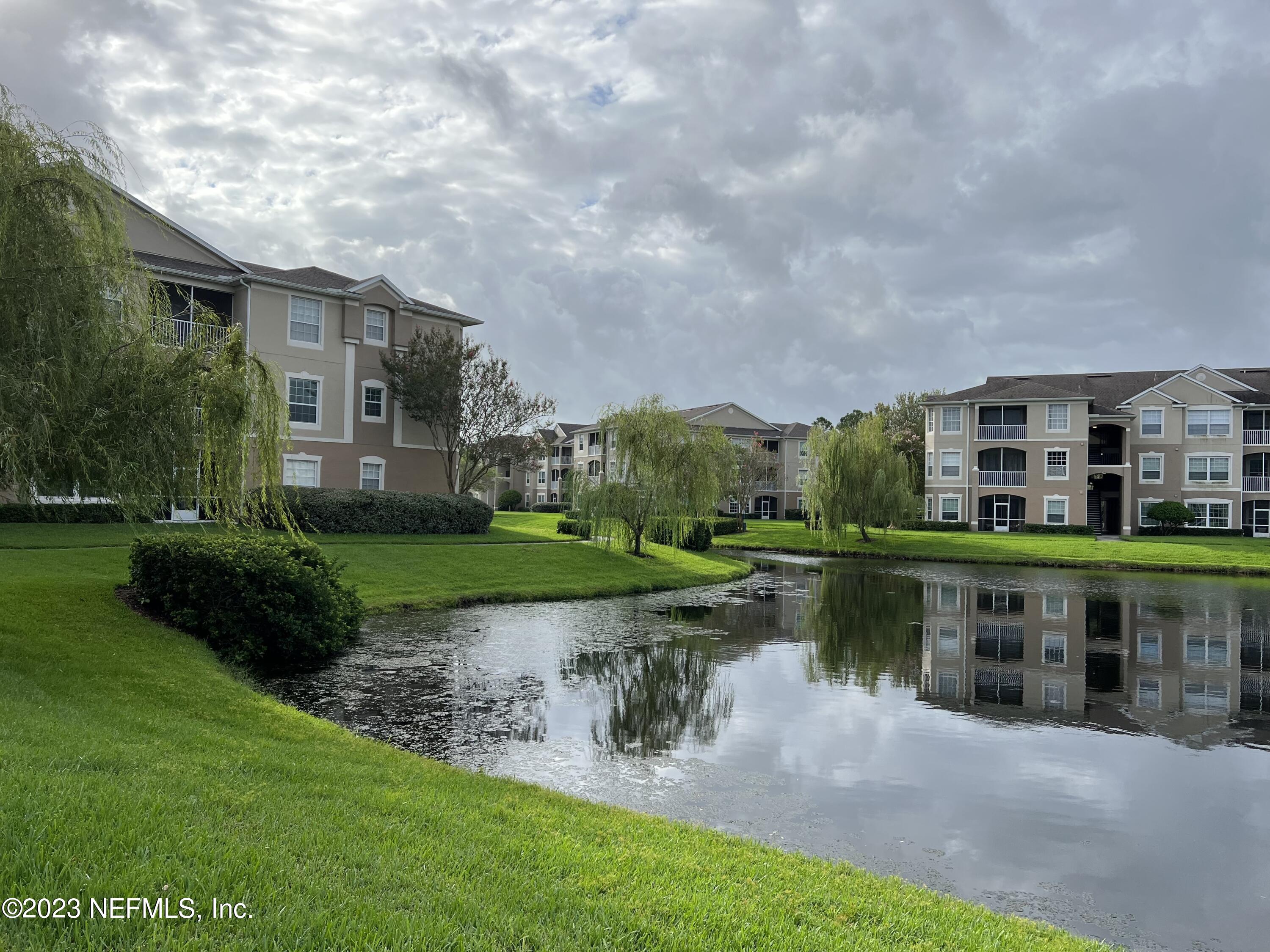 7990 Baymeadows Road East, Unit 418 Jacksonville, FL 32256 - Photo 24 of 25 a backyard of a house with a garden and lake view