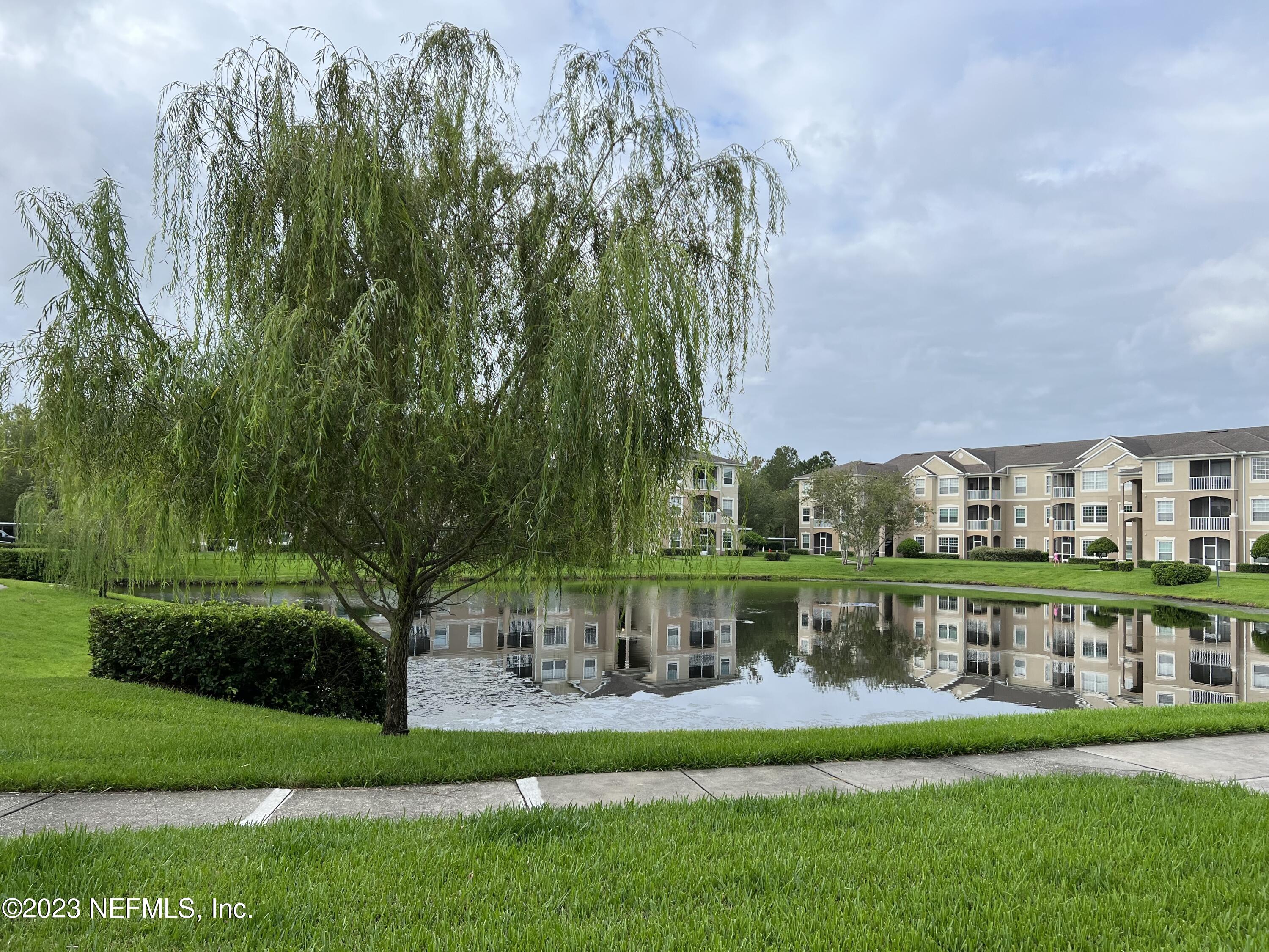 7990 Baymeadows Road East, Unit 418 Jacksonville, FL 32256 - Photo 25 of 25 a view of a big building with a big yard and potted plants and large trees
