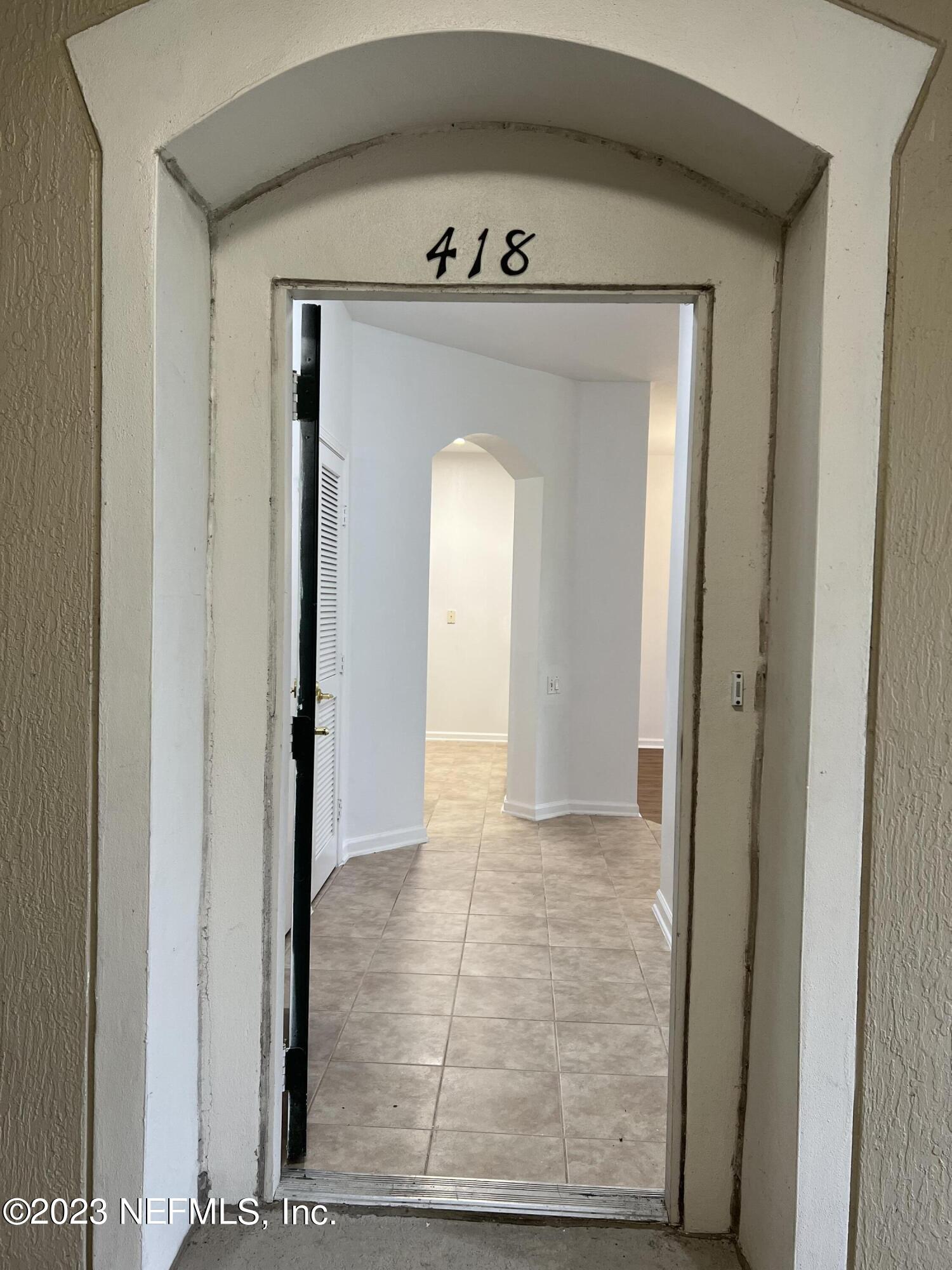 7990 Baymeadows Road East, Unit 418 Jacksonville, FL 32256 - Photo 10 of 25 a view of a hallway with wooden floor and a glass door