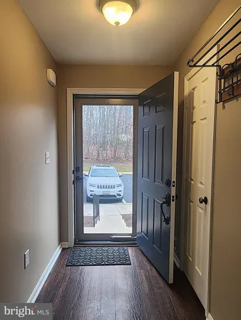a view of a hallway with wooden floor and a glass door