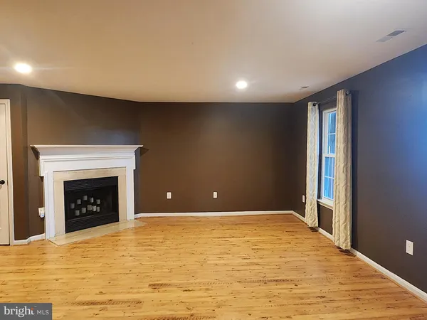 a view of an empty room with window and fire place