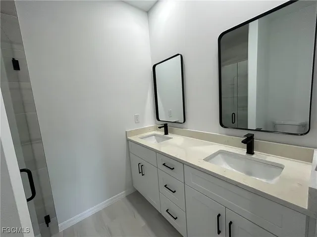 a bathroom with double vanity sink and two mirror