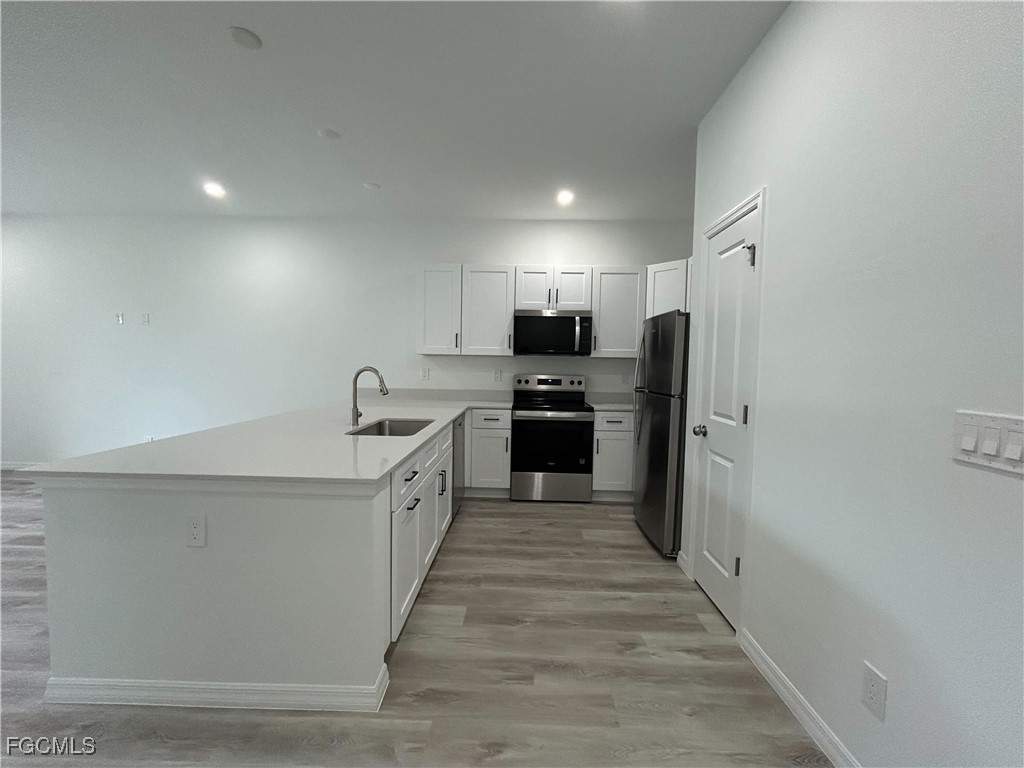 453 Bell Boulevard Lehigh Acres, FL 33974 - Photo 2 of 21 a large kitchen with a large counter top stainless steel appliances and cabinets