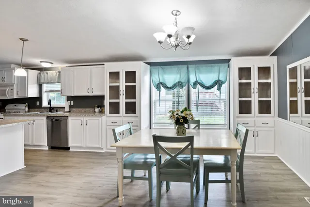 a view of a dining room with furniture large windows and wooden floor