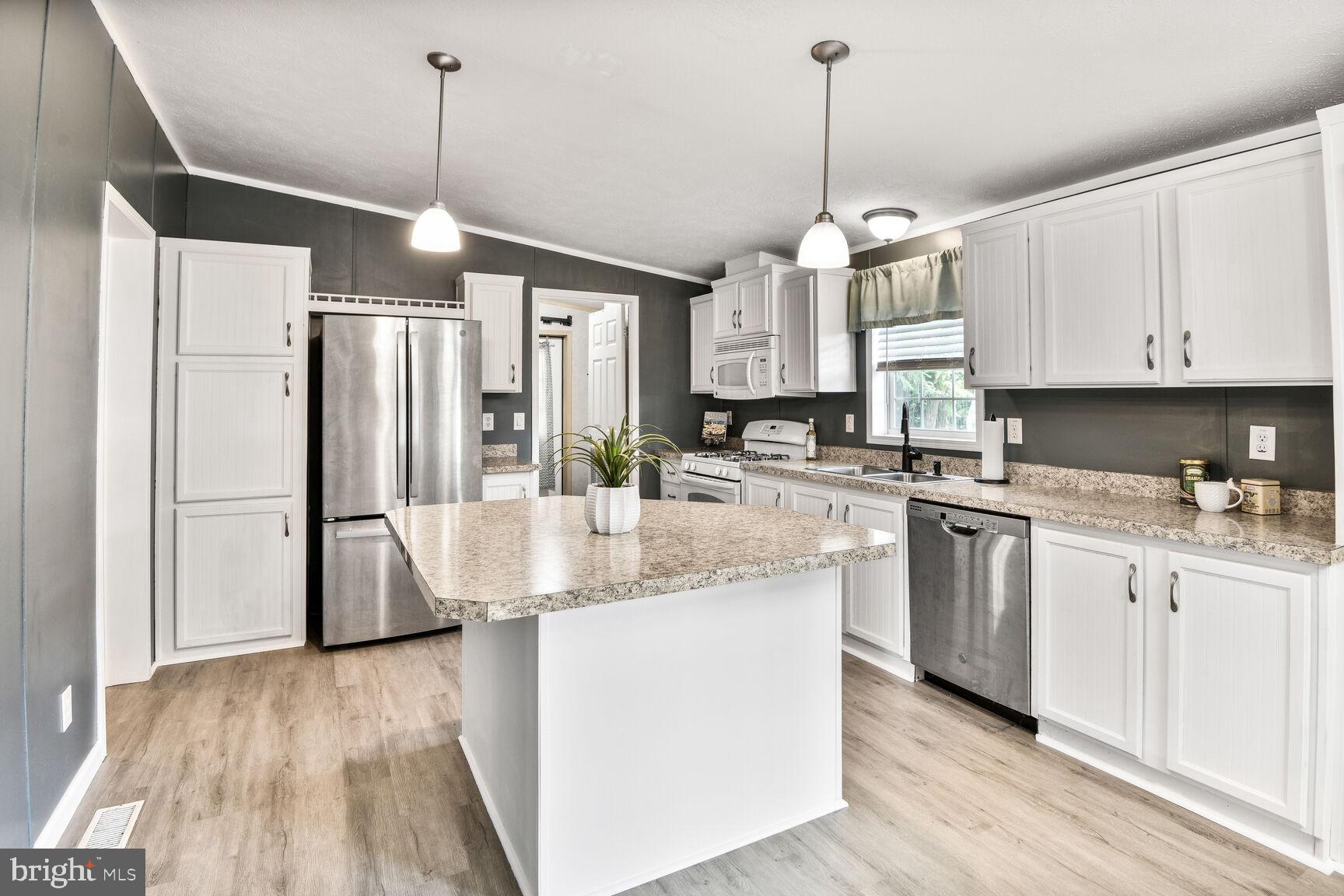 488 North Patuxent Road, Unit 19A Odenton, MD 21113 - Photo 2 of 14 a kitchen with stainless steel appliances granite countertop a refrigerator a sink dishwasher a stove and white cabinets with wooden floor