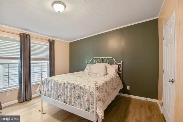 a bedroom with a bed and large windows