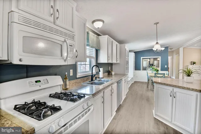 a kitchen with a stove a sink and cabinets