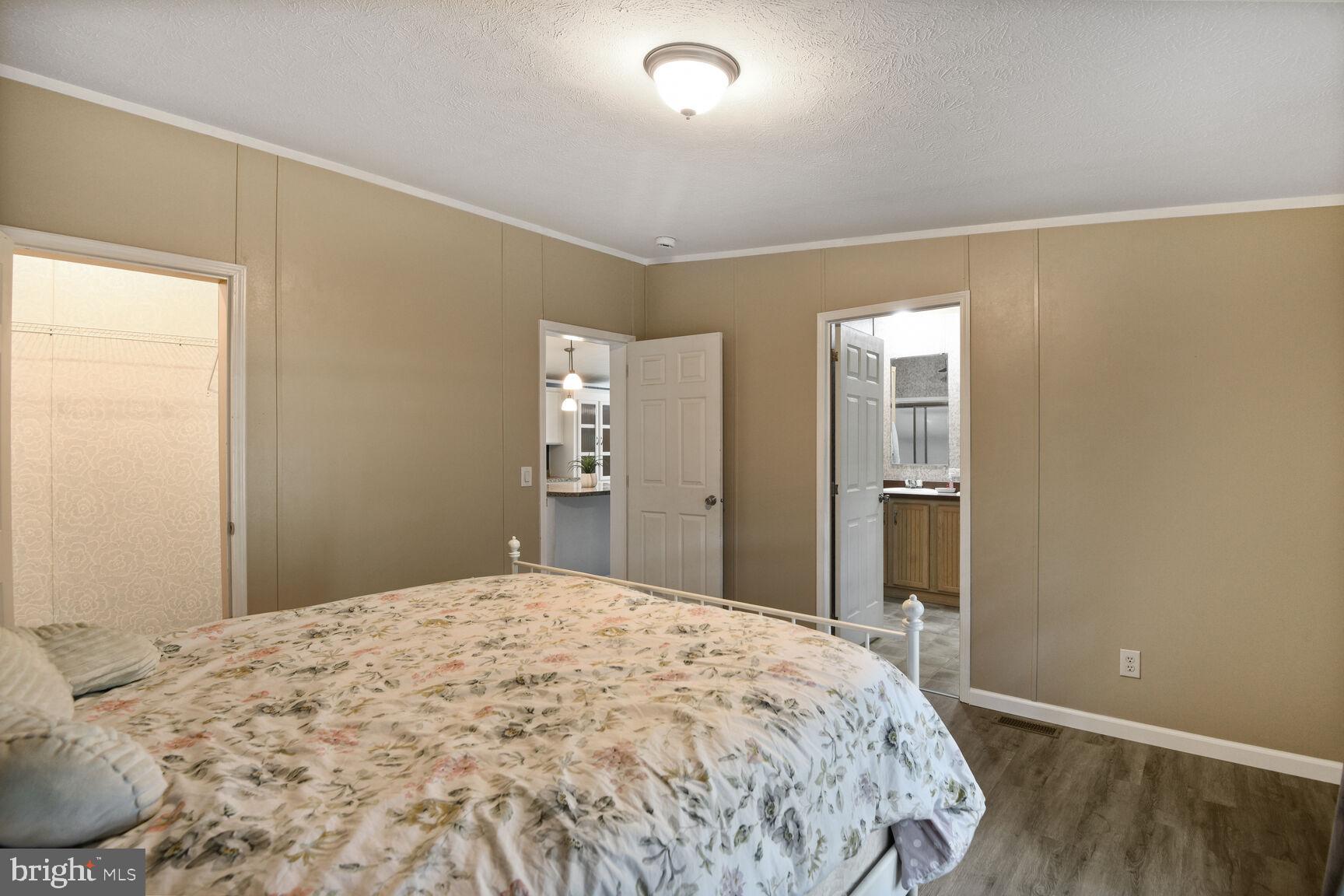 488 North Patuxent Road, Unit 19A Odenton, MD 21113 - Photo 8 of 14 a bedroom with a large bed and wooden floor
