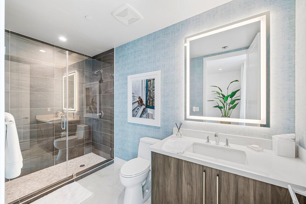 475 East Royal Palm Road, Unit 805 Boca Raton, FL 33432 - Photo 27 of 41 a bathroom with a granite countertop sink a toilet a mirror and shower