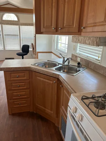 a kitchen with kitchen island granite countertop wooden floors and a sink