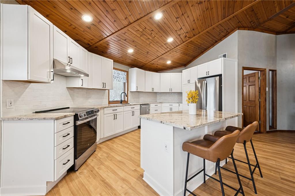 50 Potato Run Road Washington, PA 15301 - Photo 4 of 43 a kitchen with stainless steel appliances kitchen island granite countertop a stove a sink a refrigerator and white cabinets with wooden floor