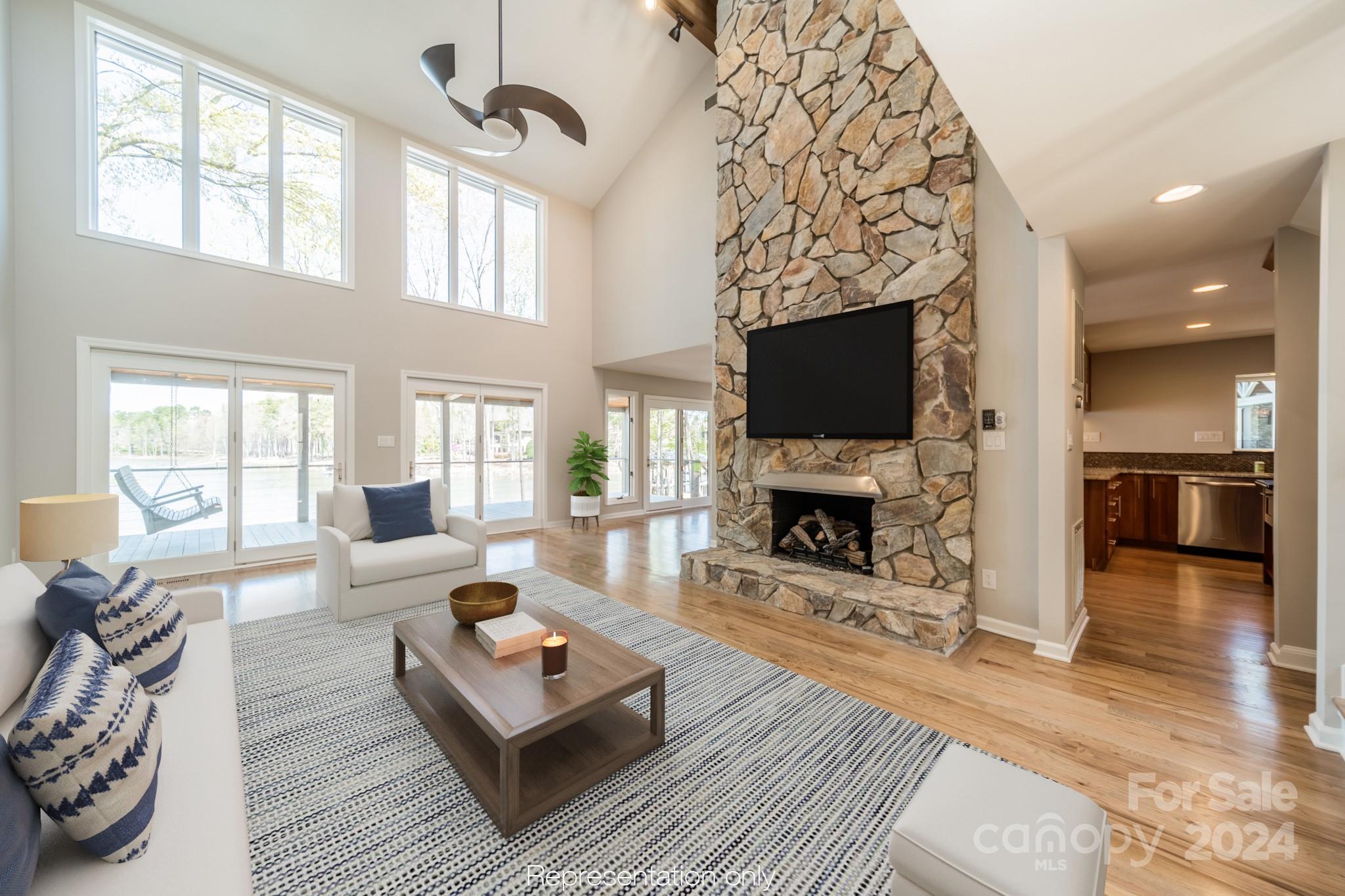 114 Stonemarker Road Mooresville, NC 28117 - Photo 14 of 38 a living room with furniture a fireplace a flat screen tv and a large window