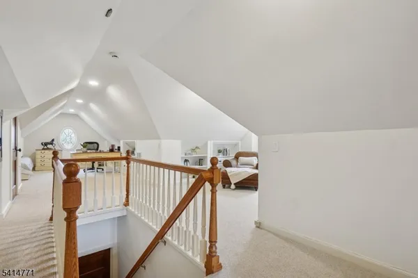 a bedroom with a bed a clock and a bookshelf with wooden floor
