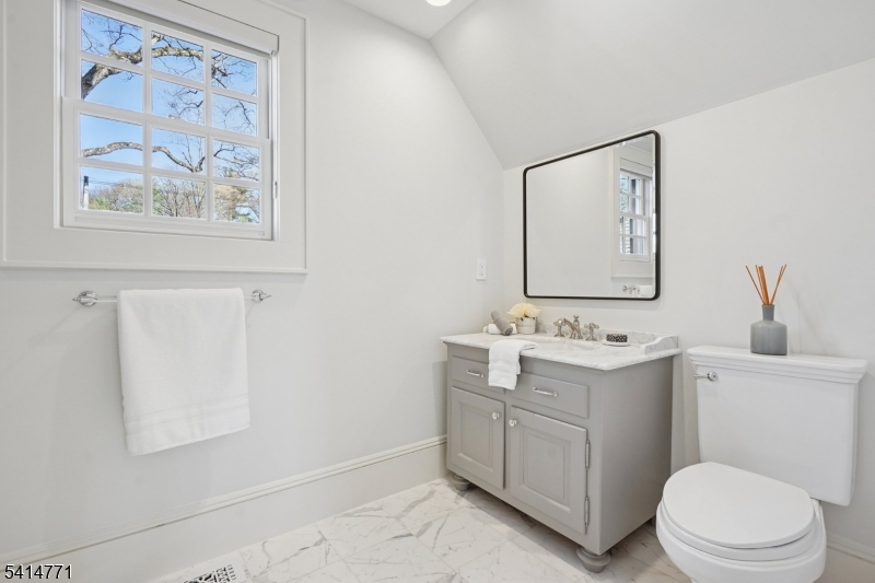 55 Oxbow Lane Summit, NJ 07901 - Photo 34 of 50 a bathroom with a toilet sink vanity and mirror