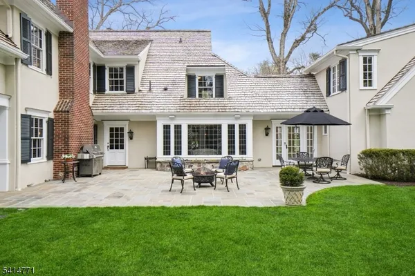 a view of a house with backyard and sitting area
