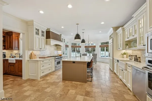 a kitchen with stainless steel appliances kitchen island granite countertop a stove a sink and a refrigerator