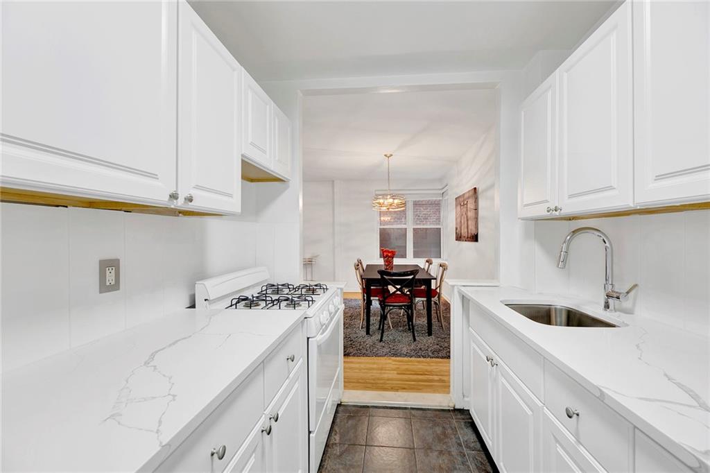 9411 Shore Road, Unit 1A Brooklyn, NY 11209 - Photo 10 of 19 a kitchen with a sink a stove and cabinets