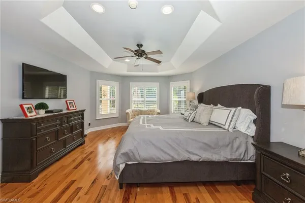 a spacious bedroom with a bed and a flat screen tv