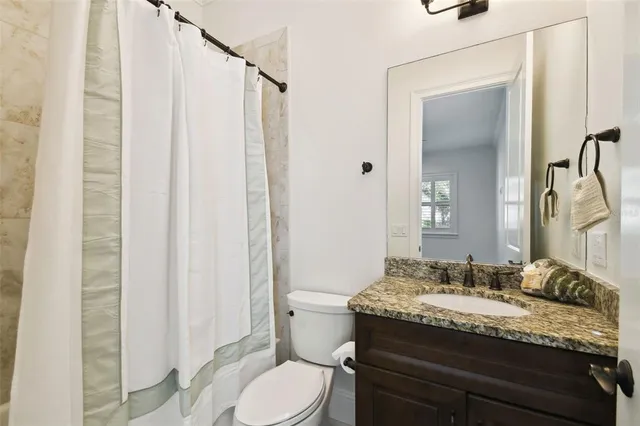 a bathroom with a granite countertop sink toilet and shower