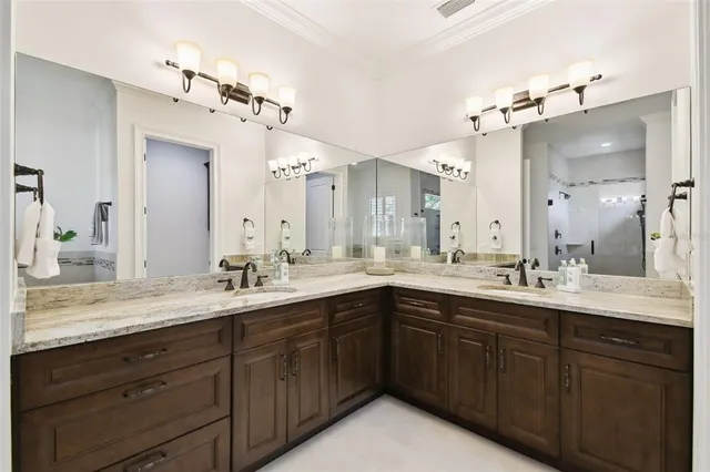a bathroom with a sink double vanity granite and a mirror