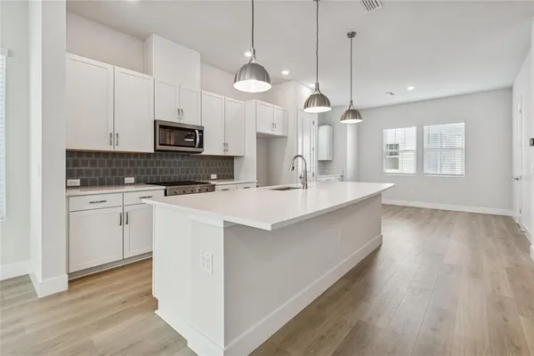 a kitchen with kitchen island white cabinets and wooden floor