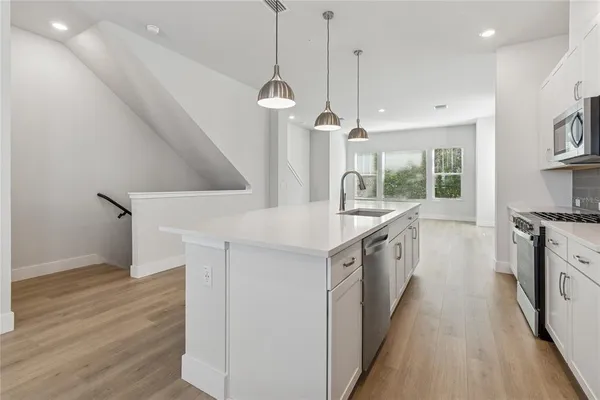 a kitchen with stainless steel appliances granite countertop a sink stove and cabinets