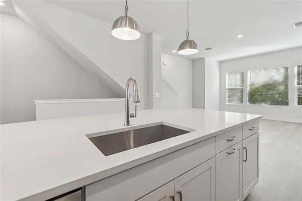 a kitchen with sink stove and wooden floor