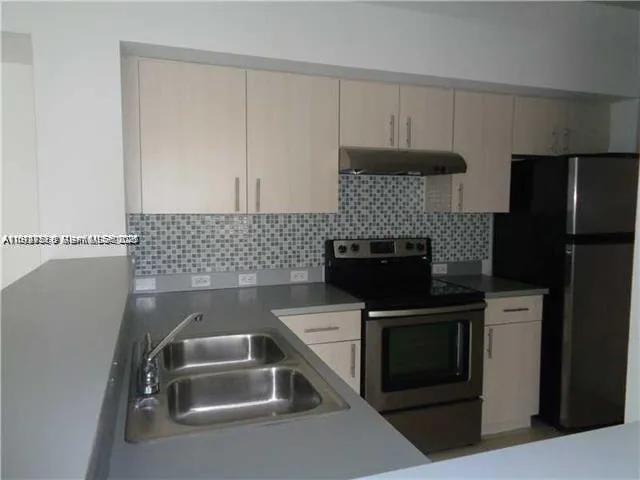 a kitchen with a sink and a refrigerator