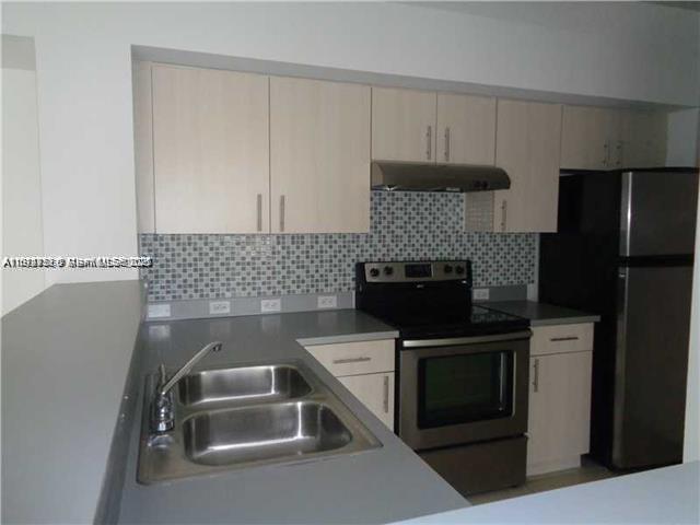 720 Southwest 111th Avenue, Unit 207 Pembroke Pines, FL 33025 - Photo 13 of 13 a kitchen with a sink and a refrigerator