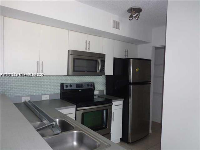 720 Southwest 111th Avenue, Unit 207 Pembroke Pines, FL 33025 - Photo 5 of 13 a kitchen with a microwave a stove and a microwave