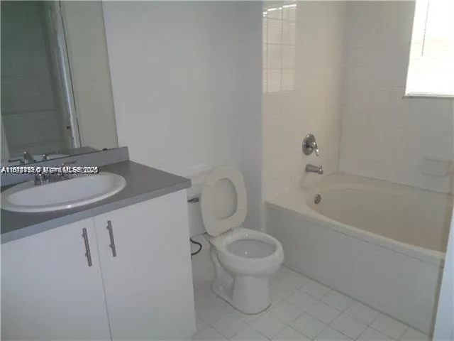 a bathroom with a granite countertop sink a toilet and bathtub
