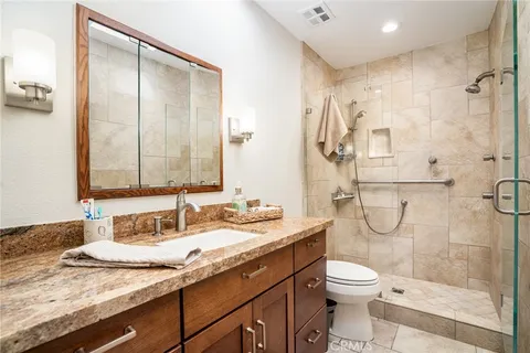 a bathroom with a granite countertop sink and a mirror